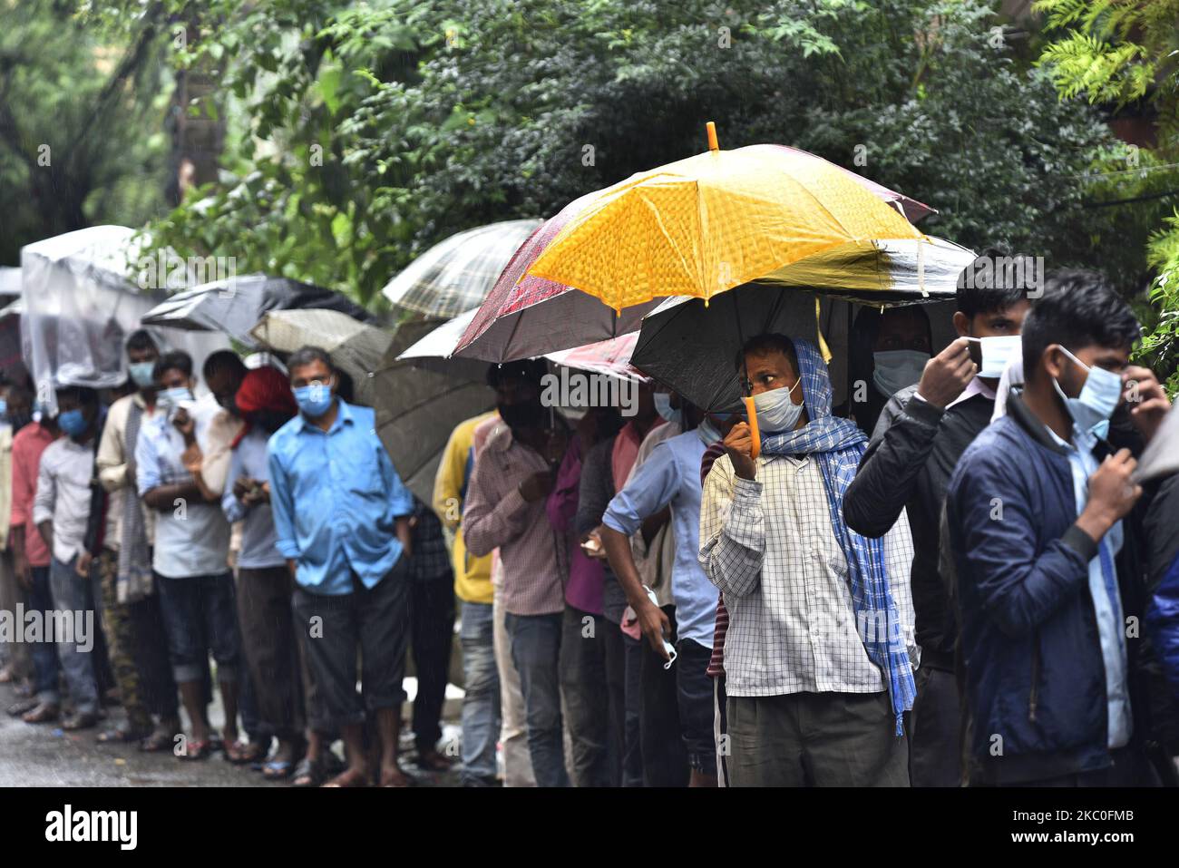 I nepalesi e i lavoratori migranti indiani insieme ad un rivestimento ombrello per il test PCR all'esterno al Sukraraj Tropical & Infectious Disease Hospital, Teku, Kathmandu, Nepal il 24 settembre 2020. (Foto di Narayan Maharjan/NurPhoto) Foto Stock