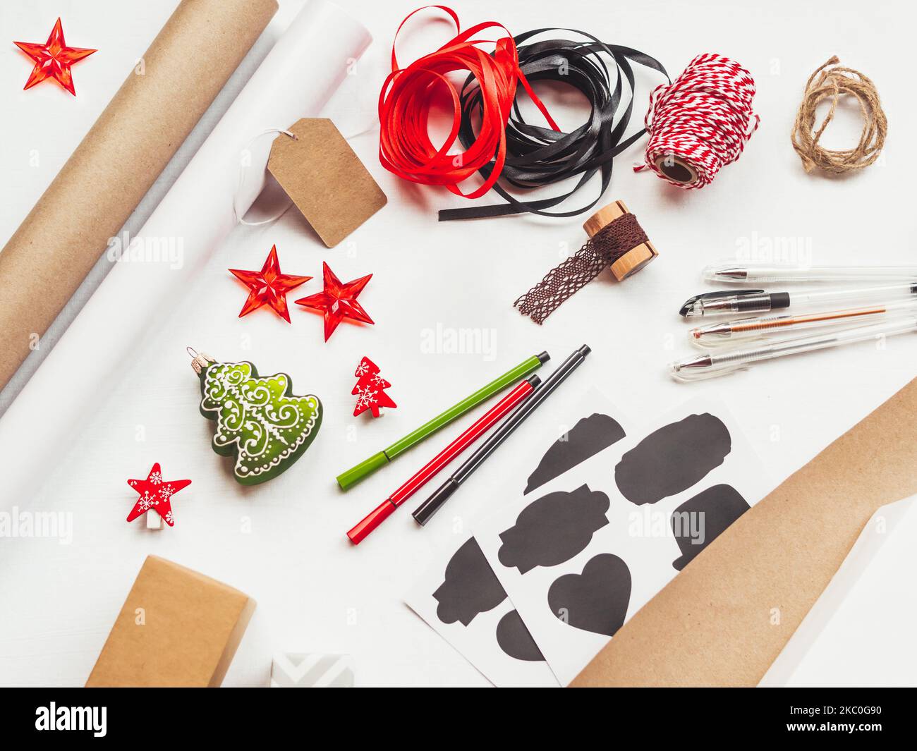 Vista dall'alto sul tavolo con decorazioni natalizie. Materiale per la confezione dei regali. Sfondo piatto e festivo. Regali fai da te per le vacanze invernali. Foto Stock