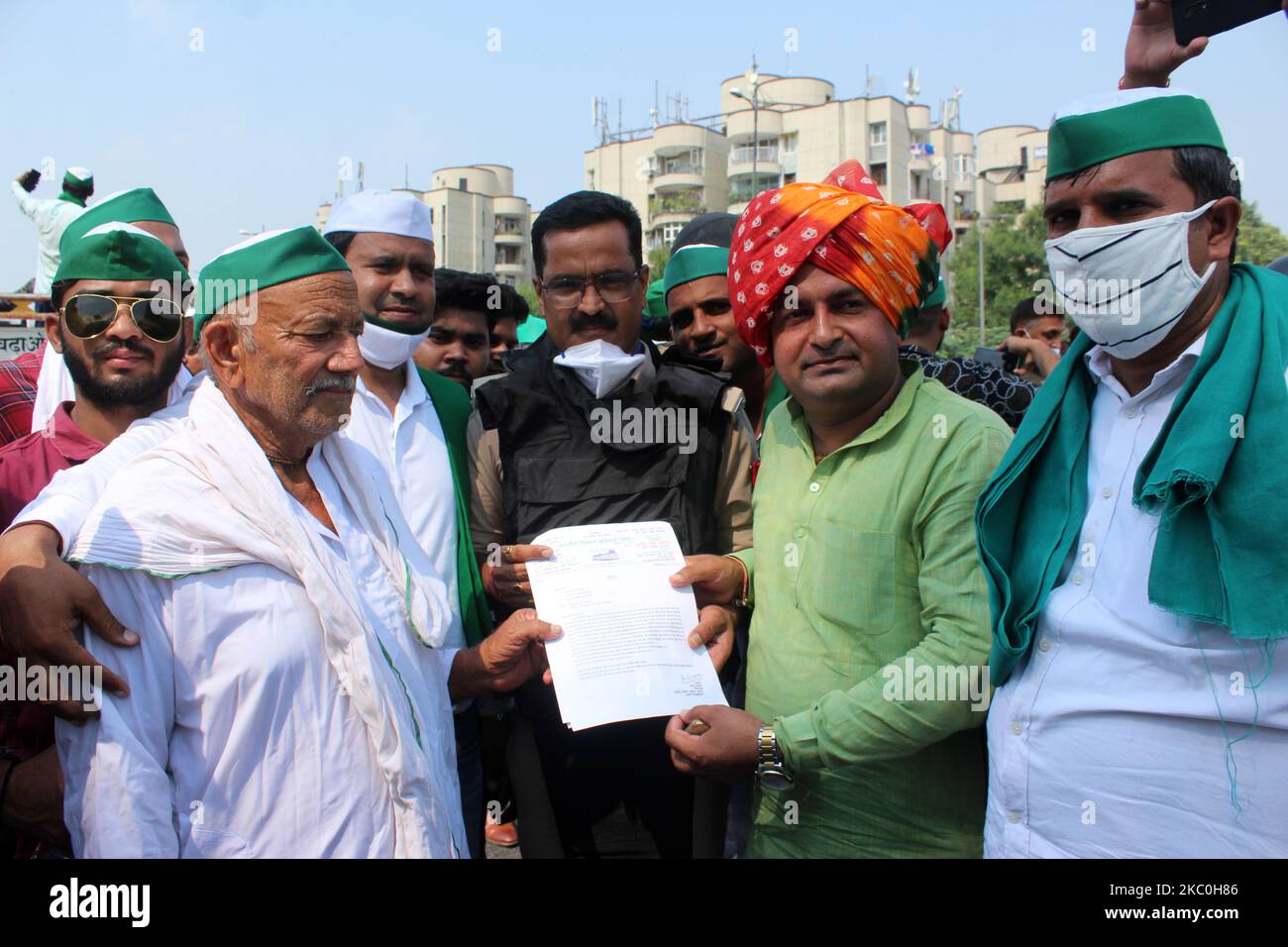 I membri dell'Unione di Bharatiya Kisan (BKU) sono visti consegnare una lettera con le loro richieste a Kumar Ranvijay, DCP aggiuntivo, Noida al confine Delhi-Noida in protesta contro le fatture di fattoria approvate dal governo modi il 25 settembre 2020 a Noida, India. Contadini di diversi villaggi si sono riuniti a marzo a Delhi come parte di una protesta nazionale in tutto il paese. (Foto di Mayank Makhija/NurPhoto) Foto Stock