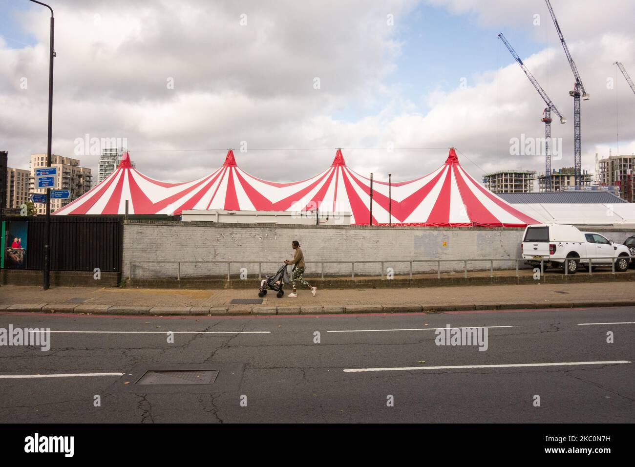 Una giovane madre che spinge un bambino in un passeggino davanti al Backyard Cinema, Armoury Way, Wandsworth, Londra, Inghilterra, REGNO UNITO Foto Stock