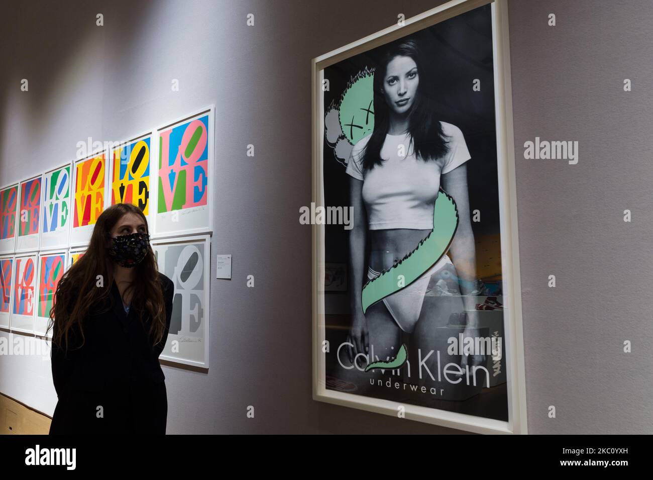 Un membro dello staff della galleria guarda Untitled (Calvin Klein), 1999,  di KAWS (prezzo di vendita stimato £80.000 - 120.000) durante una chiamata  fotografica per la vendita di Bonhams Pop x Culture,