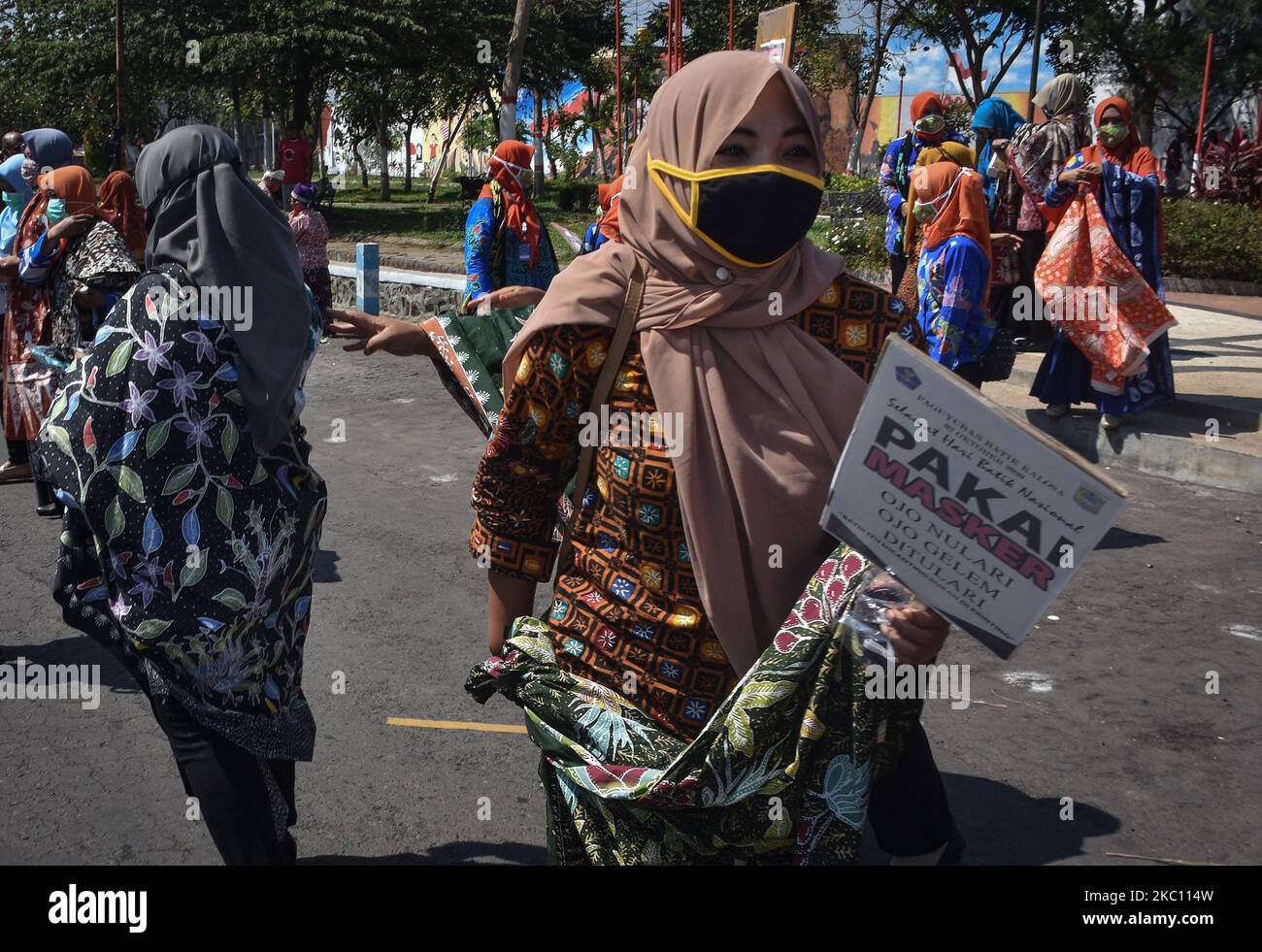 Alcuni artigiani batik e stilisti che indossano abiti batik distribuiscono maschere agli utenti della strada a Karangploso City, Malang, East Java, il 02 ottobre 2020. Questa attività è stata uno sforzo per la campagna per la conservazione del patrimonio culturale indonesiano Batik durante l'epidemia di Covid-19. (Foto di Aman Rochman/NurPhoto) Foto Stock