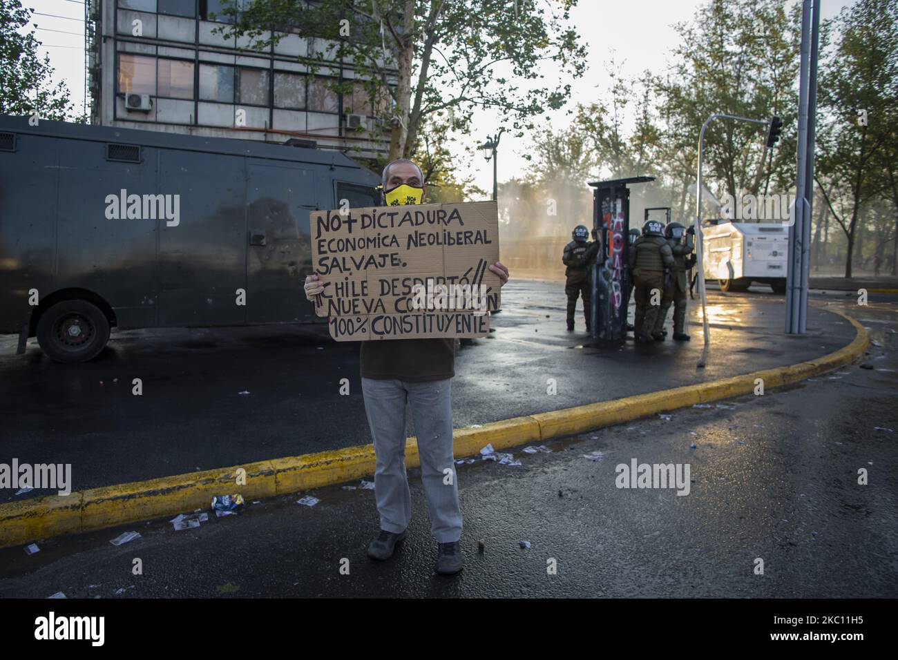Un uomo ha in mano un poster con la frase: Niente più dittatura, economia liberale selvaggia. Il Cile si è svegliato, nuova costituzione, 100% costituente - per protestare contro il governo dell'era Sebastian PiÃ±, la disuguaglianza sociale e il sistema neoliberale. InSantiago de Chile, il 2 ottobre 2020. (Foto di Claudio Abarca Sandoval/NurPhoto) Foto Stock
