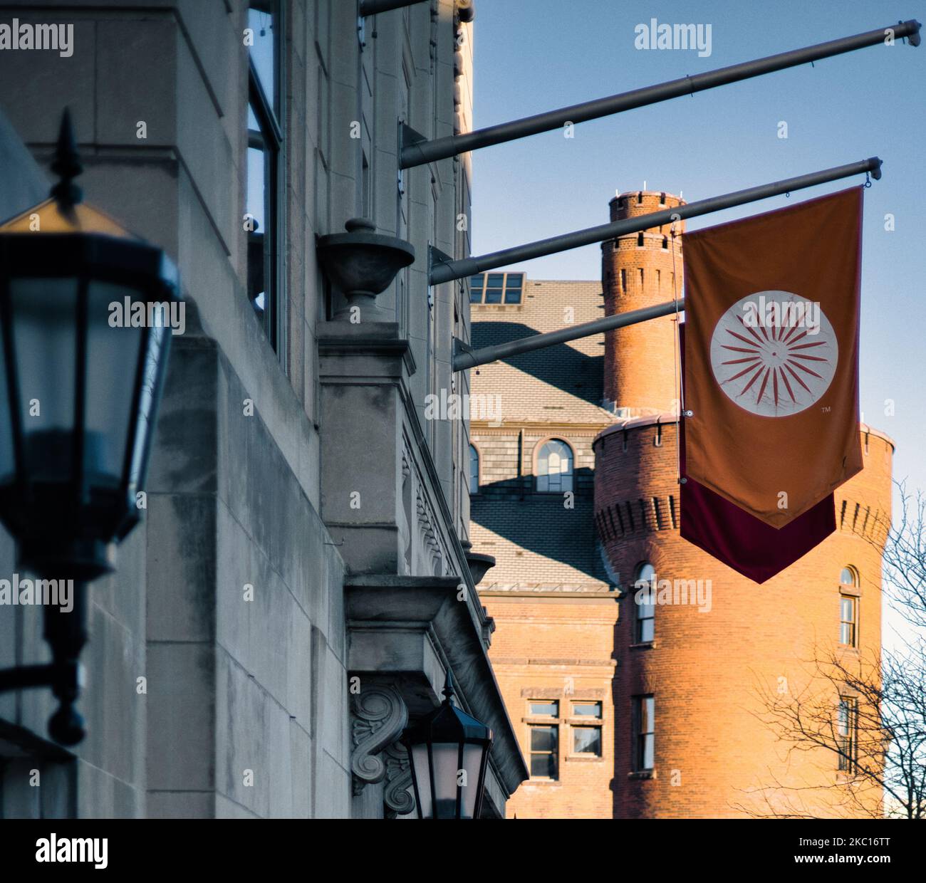 Una bandiera rossa con un simbolo circolare bianco su di essa di fronte a un edificio simile a un castello a Madison, Wisconsin, in una giornata di sole Foto Stock