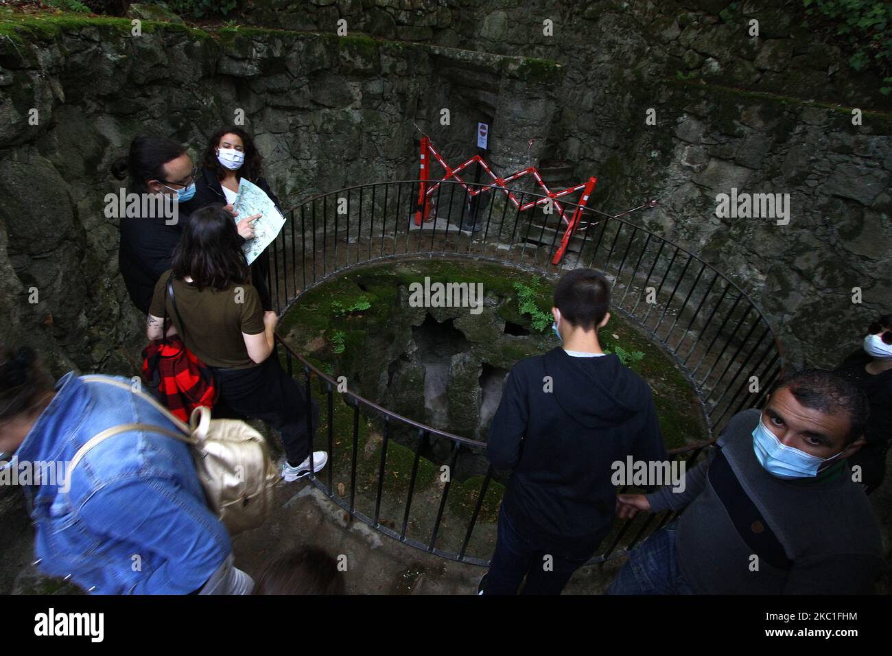 I turisti che indossano maschere protettive camminano attraverso l'attrazione 'Pozo Imperfecto' a Quinta das Regaleiras, a Sintra, Portogallo. 09 ottobre 2020. Con la fine del periodo delle vacanze europee, è diventato chiaro che il covid-19 ha avuto un impatto significativo sul settore turistico dopo decenni di crescita costante. Le misure volte a contenere la diffusione del coronavirus, comprese le restrizioni alla mobilità e i divieti di viaggio, hanno ridotto i flussi turistici, secondo quanto dichiarato dall'agenzia di rating DBRS Morningstar. (Foto di Jorge Mantilla/NurPhoto) Foto Stock