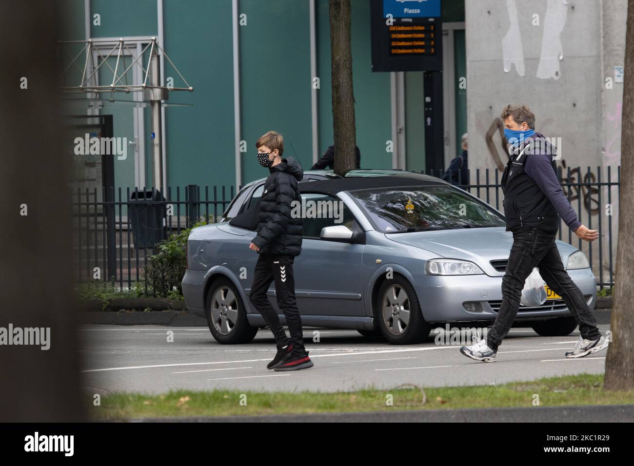 Vita quotidiana nella città di Eindhoven nei Paesi Bassi con persone che indossano il facemask come fuori a piedi o in bicicletta come misura protettiva contro la diffusione della pandemia di Coronavirus Covid-19. Martedì 13 ottobre 2020 il primo ministro olandese Mark Rutte ha annunciato che i Paesi Bassi devono tornare ad un blocco parziale, chiudendo i bar e i ristoranti, l'uso obbligatorio della maschera facciale al chiuso, la limitazione al numero di persone che si riuniscono al chiuso, le attività sportive e altro ancora sono interessati. Il paese è stato uno dei principali focolai in Europa. Eindhoven, Paesi Bassi il Martedì 13 Foto Stock