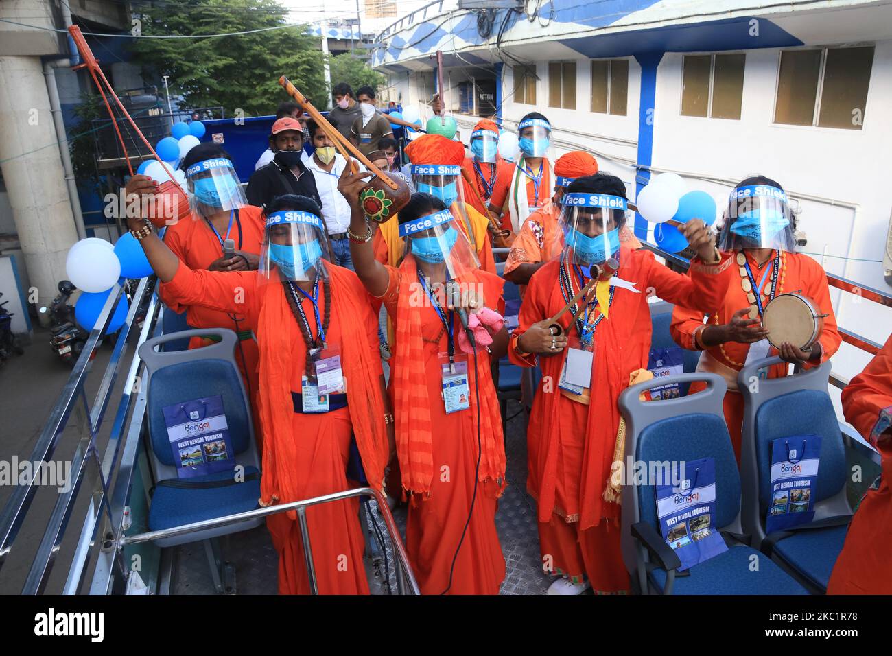Gli artisti folkloristici indiani indossano un equipaggiamento protettivo e si esibiscono sull'autobus per mostrare la cultura del Bengala su un ampio autobus a due piani durante il Bengala Occidentale il primo ministro Mamata Banerjee inaugura autobus a due piani a Kolkata il 13,2020 ottobre. Gli autobus a due piani sono stati introdotti negli anni '1920s. L'era governo del fronte sinistro li ha eliminati all'inizio degli anni '1990s. Nel 2005, l'ultimo autobus è andato fuori dalle strade della città. Nel 2011, dopo essere venuto al potere, Mamata Banerjee ha diretto il reparto trasporti per riportare gli iconici autobus. I nuovi autobus avranno caratteristiche come porte automatiche, destinazione bo Foto Stock