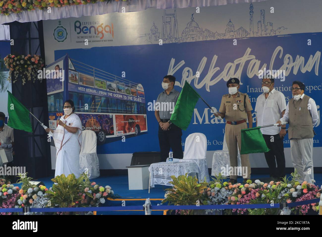 Bandiera del Bengala Occidentale (sinistra) Mamata Banerjee inaugura autobus a due piani a Kolkata il 13 ottobre 2020. Gli autobus a due piani sono stati introdotti negli anni '1920s. L'era governo del fronte sinistro li ha eliminati all'inizio degli anni '1990s. Nel 2005, l'ultimo autobus è andato fuori dalle strade della città. Nel 2011, dopo essere venuto al potere, Banerjee ha diretto il reparto trasporti a riportare gli iconici autobus. I nuovi autobus avranno caratteristiche come porte automatiche, tavole di destinazione, pulsanti antipanico e telecamere CCTV. Mentre i vecchi autobus erano dotati di due porte, queste avranno una porta. Dei 51 posti, il Foto Stock