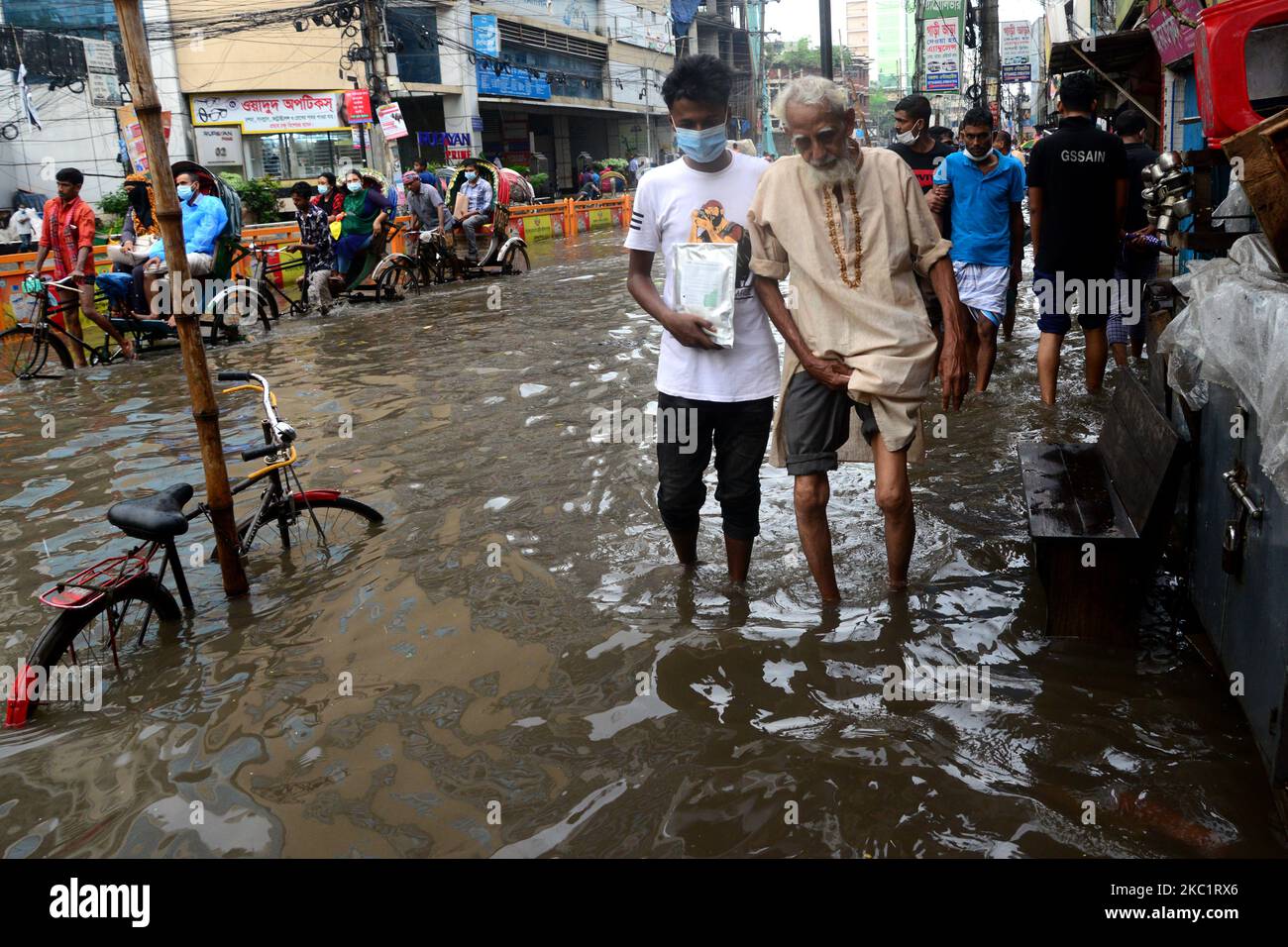 I veicoli provano a guidare e i cittadini camminano per le strade di Dhaka in Bangladesh, il 14 ottobre 2020. Il pesante versamento di monsoni ha causato un'eccessiva disboscamento dell'acqua nella maggior parte delle zone della città di Dhaka, Bangladesh. Le strade sono state sommerse rendendo i viaggi lenti e pericolosi. (Foto di Mamunur Rashid/NurPhoto) Foto Stock