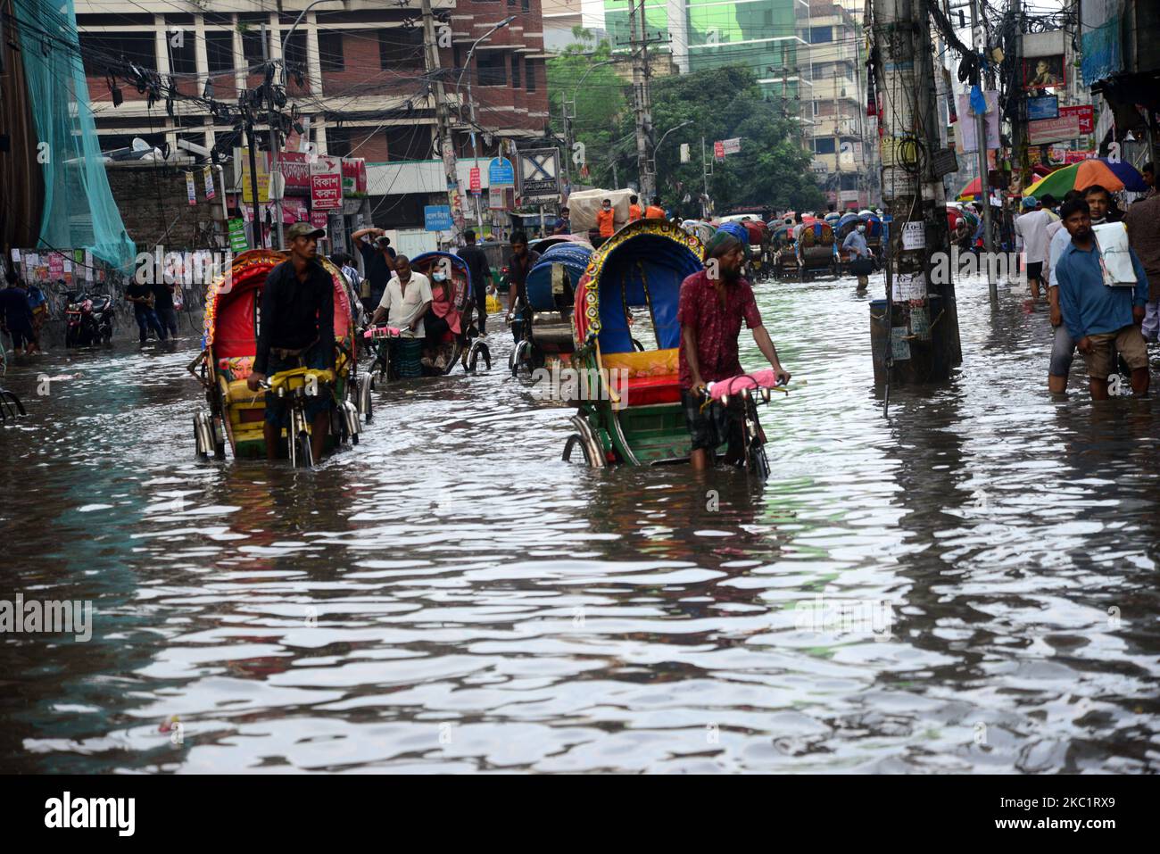 I veicoli provano a guidare e i cittadini camminano per le strade di Dhaka in Bangladesh, il 14 ottobre 2020. Il pesante versamento di monsoni ha causato un'eccessiva disboscamento dell'acqua nella maggior parte delle zone della città di Dhaka, Bangladesh. Le strade sono state sommerse rendendo i viaggi lenti e pericolosi. (Foto di Mamunur Rashid/NurPhoto) Foto Stock