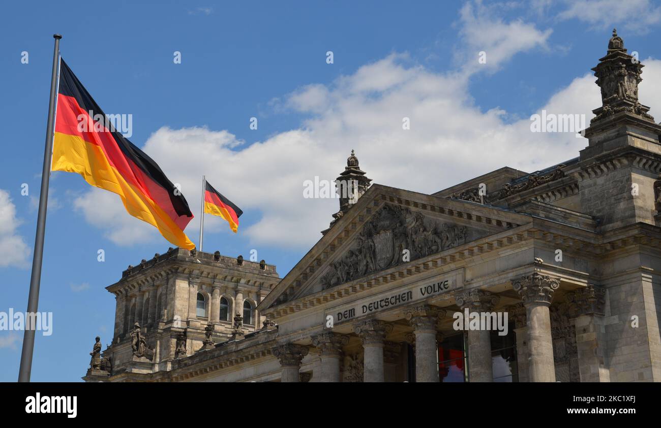 Bandiere tedesche davanti e in cima al tedesco 'Reichstag' con la scritta 'al popolo tedesco' Foto Stock
