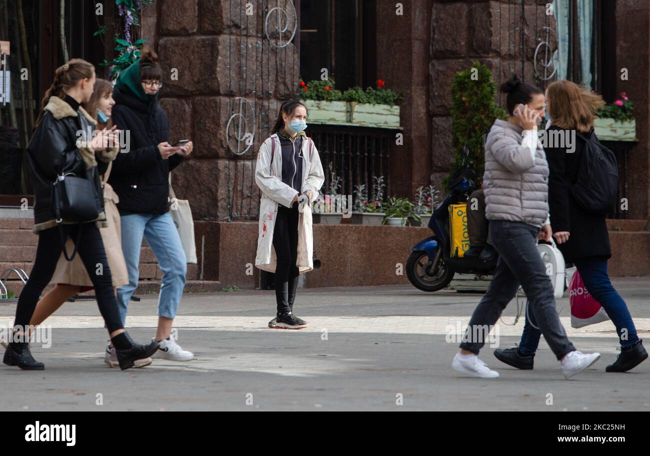 La gente cammina oltre una ragazza adolescente con la sua maschera facciale sulla strada a Kyiv, Ucraina, 19 ottobre 2020. 303.638 casi di COVID-19 confermati in Ucraina dal 19 ottobre 2020 (ore 9). Per tutto il periodo di pandemia 126.489 persone si sono ritrovate e 5.673 sono morte per COVID-19. (Foto di Sergii Kharchenko/NurPhoto) Foto Stock