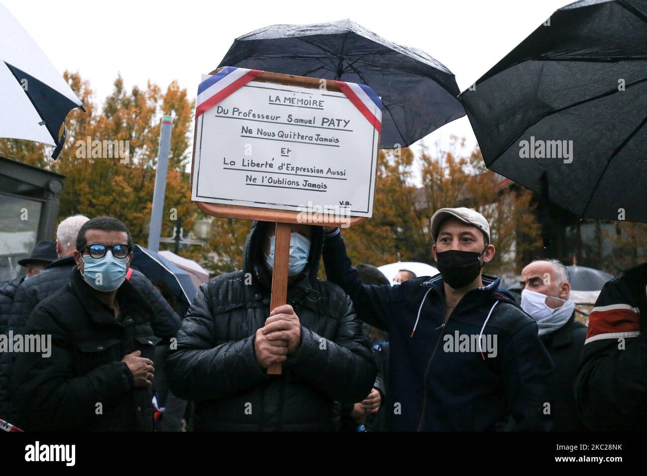 Un uomo tiene un segno che legge 'la memoria del professor Samuel Paty non sarà mai andata e così la libertà di espressione. Non dimentichiamolo mai” durante la 'Marche Blanche' del 20 ottobre 2020, a Conflans-Sainte-Honorine, a nord-ovest di Parigi, in solidarietà dopo che un insegnante è stato decapitato per mostrare agli allievi cartoni animati del Profeta Maometto. Il suo assassinio in un sobborgo di Parigi il 16 ottobre ha scioccato il paese e ha riportato alla memoria un'ondata di violenza islamista nel 2015. Paty, 47 anni, è stato attaccato il 16 ottobre sulla sua strada di casa dalla scuola secondaria superiore dove ha insegnato da 18-vecchio ceceno Abdullakh A. Foto Stock