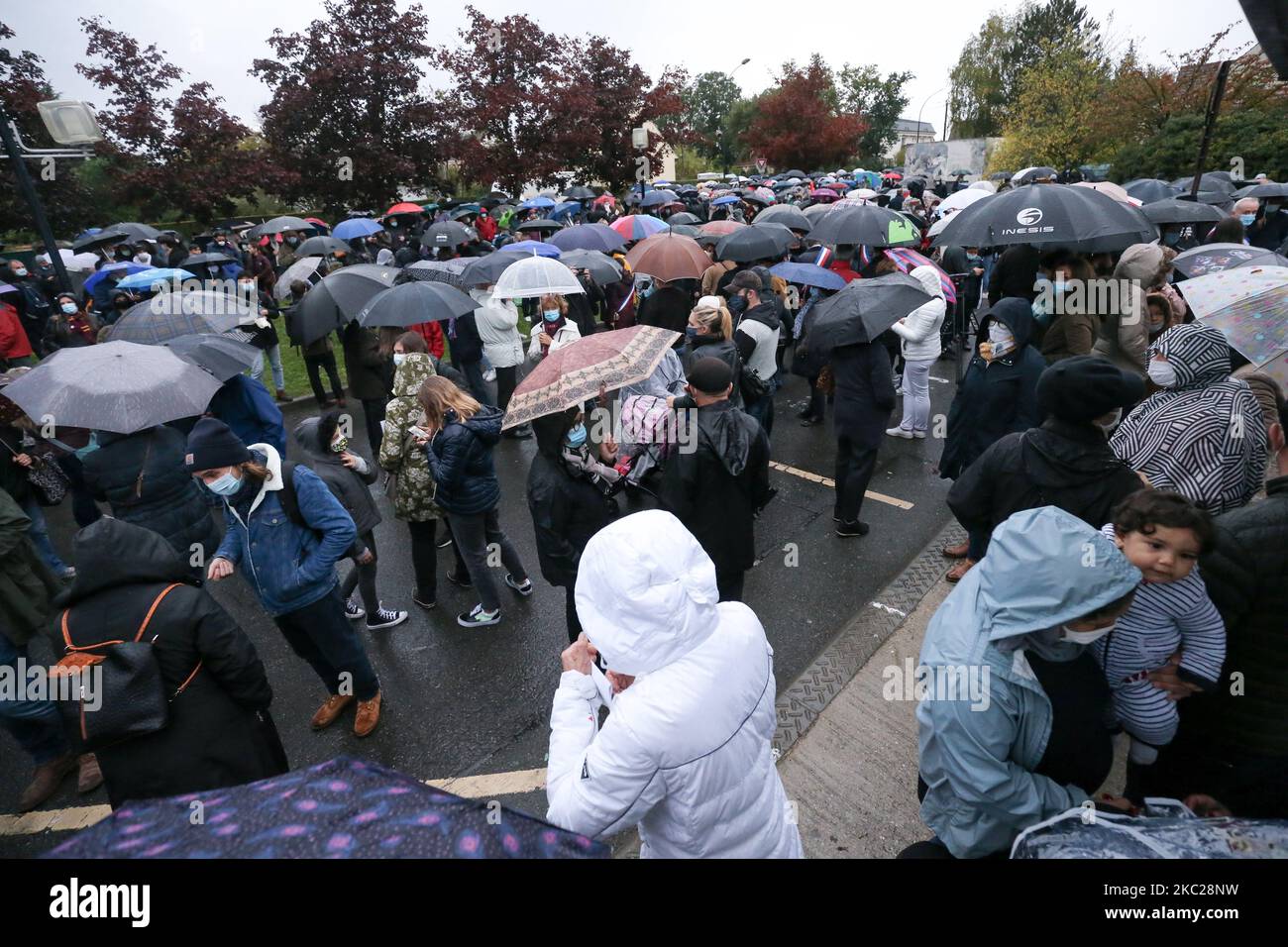 Le persone si riuniscono alla scuola media di Conflans-Sainte-Honorine, a nord-ovest di Parigi, il 20 ottobre 2020 durante la 'Marche Blanche' in solidarietà dopo che un insegnante è stato decapitato per mostrare agli studenti cartoni animati del Profeta Maometto. Il suo assassinio in un sobborgo di Parigi il 16 ottobre ha scioccato il paese e ha riportato alla memoria un'ondata di violenza islamista nel 2015. Paty, 47 anni, è stato attaccato il 16 ottobre durante il suo viaggio di ritorno dalla scuola secondaria, dove ha insegnato da un 18-vecchio ceceno Abdullakh Anzorov, che è stato ucciso a colpi di arma da fuoco dalla polizia. Dopo l'attacco, decine di migliaia di persone hanno preso parte ai rally Foto Stock