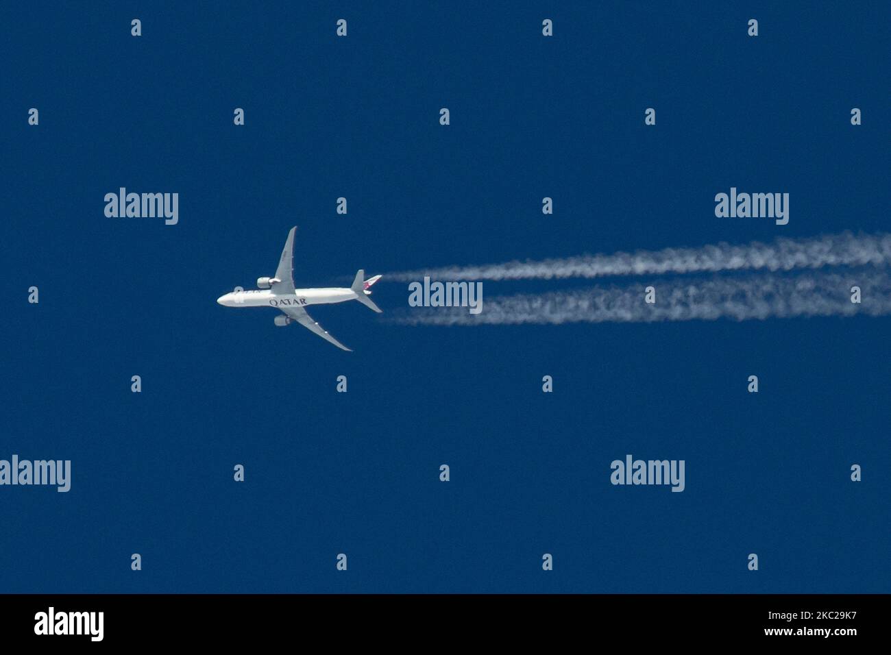 Aereo commerciale Qatar Airways Boeing 777-300ER con il logo della scritta QATAR visibile sul ventre e sul lato della fusoliera dell'aereo, sovravolare che forma lo scarico del motore contrasta dietro in alta quota a 38,000 metri nel cielo blu. L'iconico Boeing triplo sette come visto il 21 ottobre 2020 a Eindhoven, Paesi Bassi nello spazio aereo dell'Europa sopra i Paesi Bassi, in quanto sta volando una rotta a lungo raggio dall'aeroporto di Doha DOH in Qatar a Londra Heathrow LHR nel Regno Unito, volo QR7 / QTR4LA. L'aereo di sorvolo è un Boeing 777 o B773 con registrazione A7-BEH e sta volando WIT Foto Stock