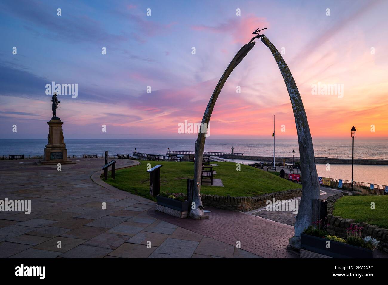 L'Arco di balena e la statua commemorativa del Capitano Cook Whitby North Yorkshire England all'alba Foto Stock