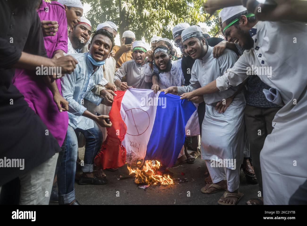 Una bandiera nazionale francese è vista bruciare sul campo durante un Islami Andolon Bangladesh, un partito politico islamista, marcia di protesta per chiedere il boicottaggio dei prodotti francesi e denunciare i commenti di Macron sulle caricature del profeta Maometto, a Dhaka il 30 ottobre 2020. (Foto di Ahmed Salahuddin/NurPhoto) Foto Stock