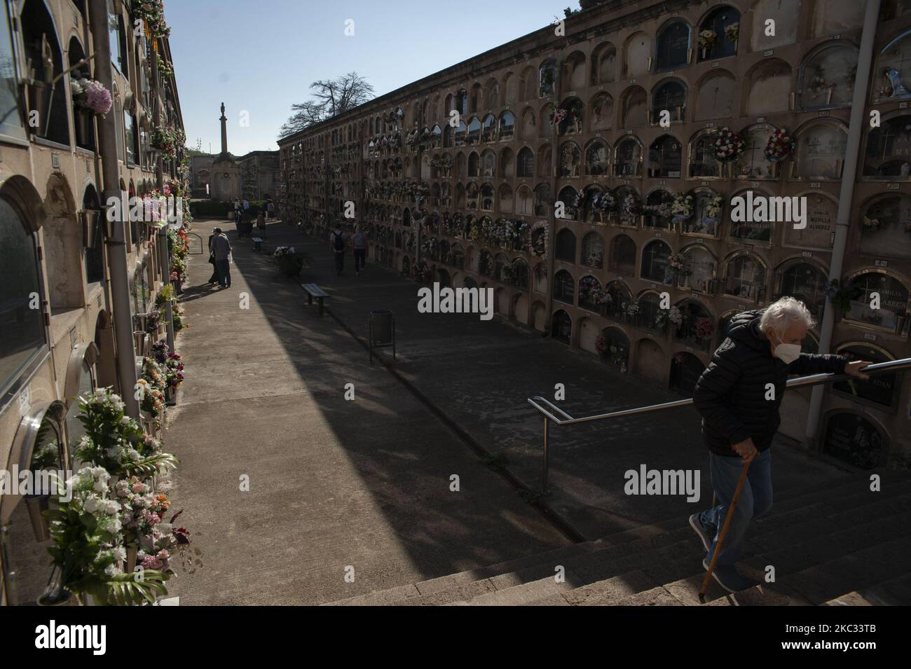 Un visitatore che indossa una maschera protettiva contro COVID-19, utilizza la ringhiera per evitare i gradini che lo separano dal defunto che visiterà a Barcellona, 1 novembre 2020. All Saints' Day, una festa cattolica per riflettere su santi e parenti defunti. (Foto di Charlie Perez/NurPhoto) Foto Stock