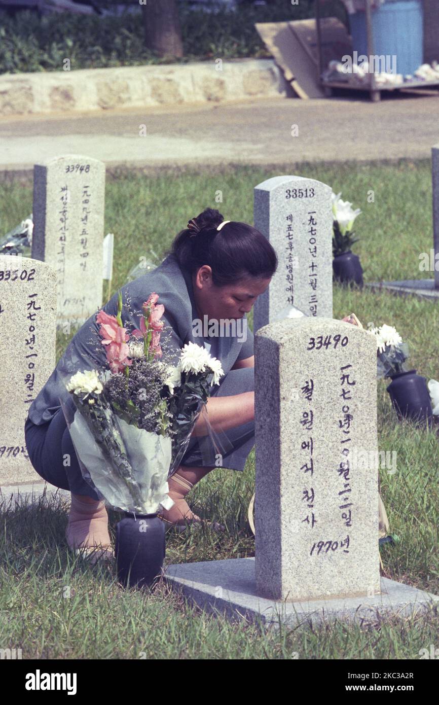 La data di questa foto scattata è il 2000. La famiglia dei morti della guerra coreana visita il cimitero nazionale dopo essersi accarezzata a Seoul, Corea del Sud. Il cimitero nazionale di Seoul si trova a Dongjak-dong, Dongjak-GU, Seoul, Corea del Sud. Quando fu istituito con decreto presidenziale di Syngman Rhee nel 1956, fu l'unico cimitero nazionale del paese. Quando il cimitero raggiunse la sua capacità all'inizio degli anni '1970s, il cimitero nazionale di Daejeon fu fondato nel 1976. Entrambi i cimiteri erano stati supervisionati dal Ministero della Difesa sudcoreano fino al 2005, ma nel 2006 il cimitero nazionale di Daejeon fu trasferito al Ministero dei Patrioti e dei Veterani Foto Stock