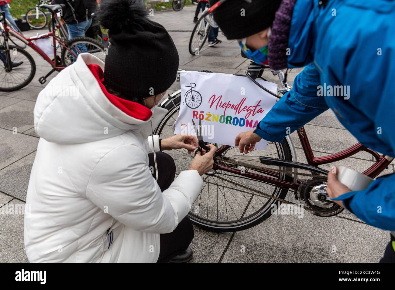 Una donna in maschera protettiva è visto a cavallo di una bicicletta con un todler sul mercato principale nella città vecchia di Cracovia, Polonia il 10 novembre 2020.. Il mercato principale di Cracovia è di solito pieno di turisti, ma oggi rimane in gran parte vuoto, poiché il turismo globale è diminuito a causa della pandemia di Covid-19. (Foto di Dominika Zarzycka/NurPhoto) Foto Stock