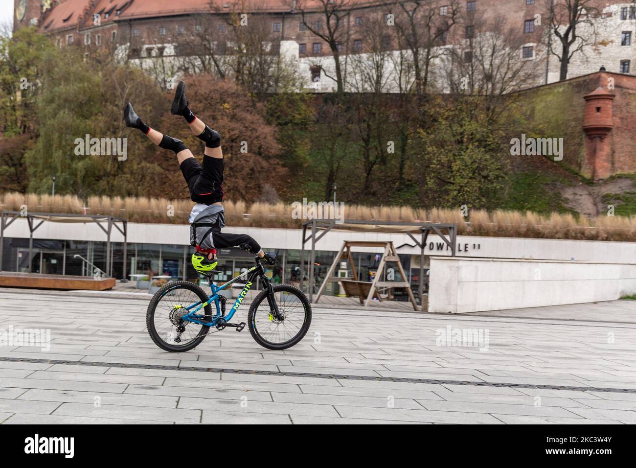 Un uomo è visto allenare le sue abilità acrobatiche freestyle su una bicicletta a Vistula Boulevards dal Castello reale di Wawel nella città vecchia di Cracovia, Polonia il 11 novembre 2020. (Foto di Dominika Zarzycka/NurPhoto) Foto Stock