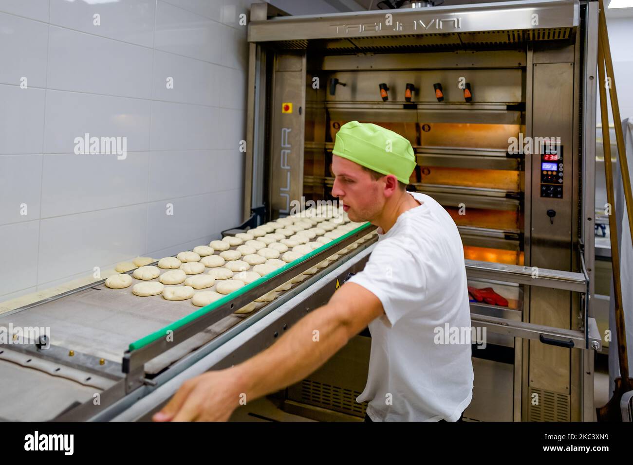 Un panettiere al lavoro tutta la notte per cuocere pane fresco durante la pandemia COVID-19, il 12 novembre 2020 a Molfetta. Secondo un'indagine condotta da Aibi-Cerved, il 85% del pane acquistato in Italia è pane artigianale fresco con una produzione media di circa 1,5 milioni di tonnellate all'anno e un consumo giornaliero pro capite di 80 grammi. Durante le settimane del blocco, le stime di Aibi confermano che il pane acquistato principalmente nei negozi e nelle panetterie locali ha aumentato la sua presenza al tavolo del 10%, tornando ai livelli di consumo di un decennio fa. (Foto di Davide Pischettola/NurPhoto) Foto Stock