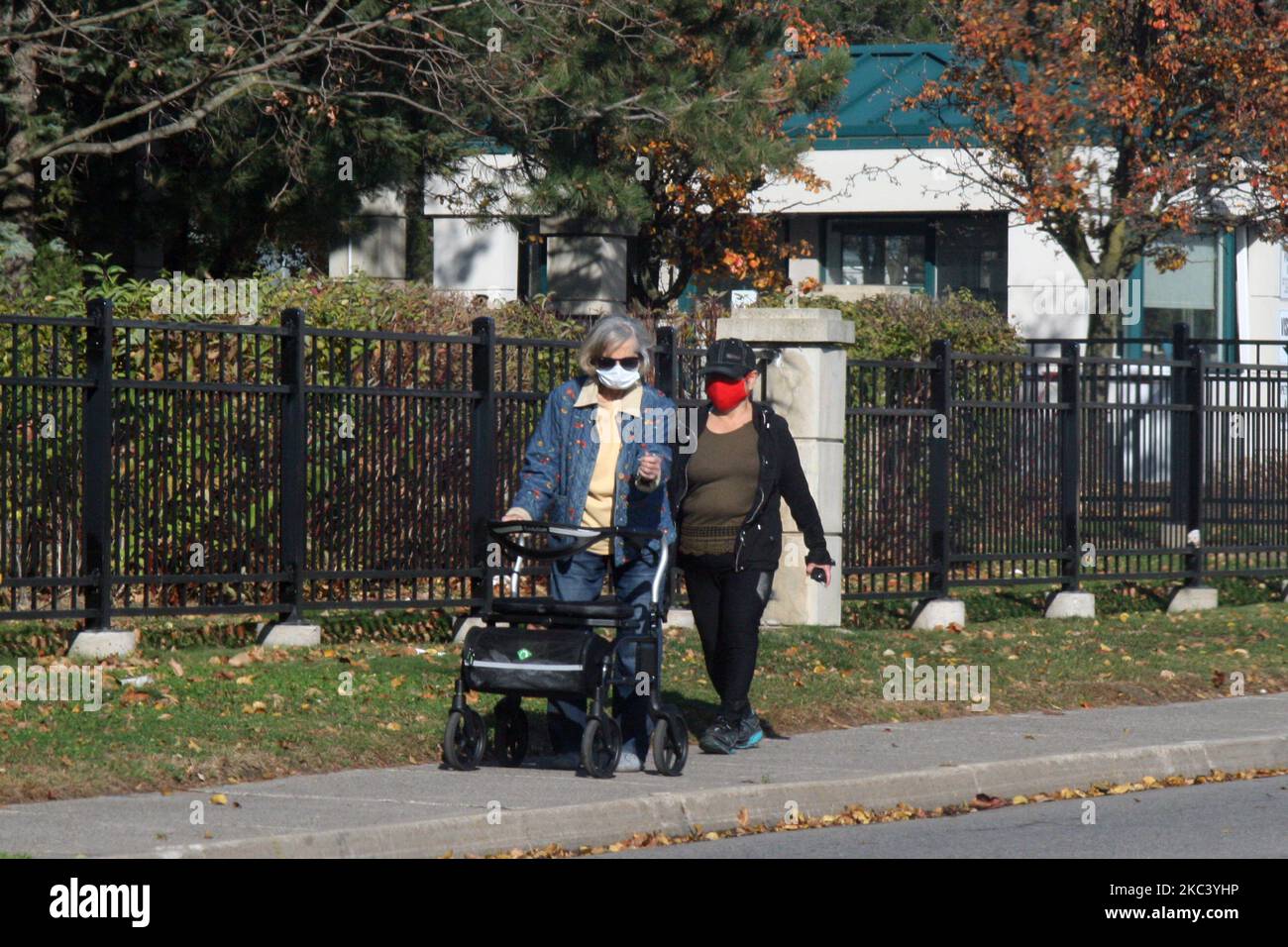 Le persone che indossano maschere facciali mentre camminano lungo la strada durante la pandemia del nuovo coronavirus (COVID-19) a Toronto, Ontario, Canada il 12 novembre 2020. L'Ontario ha riportato oggi 1.575 nuovi casi di COVID-19 e 18 decessi in più, stabilendo un nuovo record giornaliero per i casi giornalieri riportati in un periodo di 24 ore dall'inizio della pandemia. Nuove proiezioni di modellazione avvertono che l'Ontario potrebbe vedere 6.500 casi giornalieri di COVID-19 entro la metà di dicembre. Le proiezioni suggeriscono anche che il numero di pazienti COVID-19 nelle unità di terapia intensiva supererà la soglia di 150 entro due settimane, travolgendo alcuni ospedali A. Foto Stock