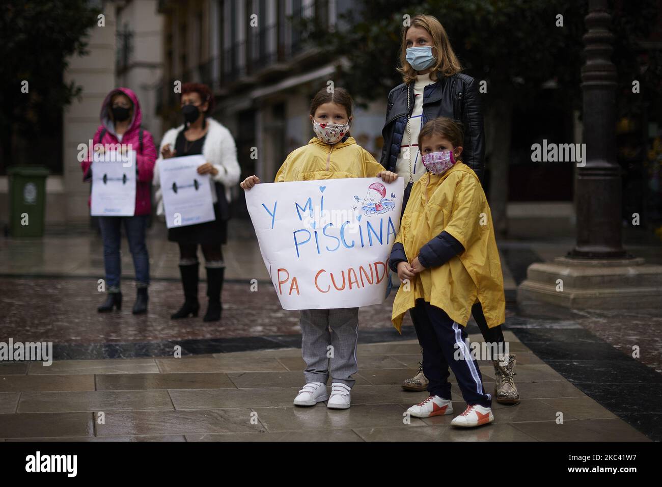 Una famiglia, con un cartello che dice "e la mia piscina quando?" Durante una protesta di palestre e centri sportivi, utenti e lavoratori che chiedono aiuto contro le ultime restrizioni del virus il 14 novembre 2020 a Granada, Spagna. Le palestre e i centri sportivi sono chiusi perché non sono considerati servizi essenziali. Le misure imposte dal governo regionale consentono l’apertura di tabacchi e non di centri in cui la salute viene operata, e questi settori sostengono che “non siamo il problema, siamo la soluzione”. (Foto di Fermin Rodriguez/NurPhoto) Foto Stock