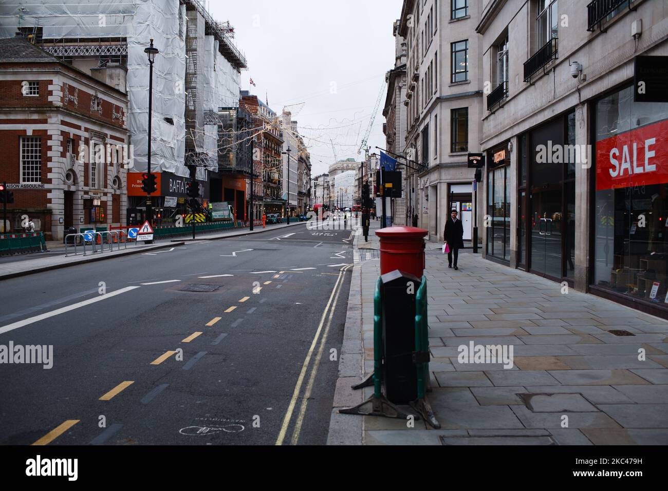 Un uomo cammina lungo una Piccadilly quasi deserta a Londra, Inghilterra, il 18 novembre 2020. In tutta l'Inghilterra negozi non essenziali, bar, ristoranti e altre aziende del settore alberghiero rimangono chiusi come parte del secondo blocco nazionale del coronavirus, iniziato il 5 novembre e in scadenza il 2 dicembre. Il primo ministro britannico Boris Johnson, che ha indicato di non voler estendere il blocco, nel frattempo rimane in isolamento a Downing Street dopo essere venuto in contatto con un deputato giovedì scorso che ha poi testato positivo per il covid-19. Il primo ministro stesso, wh Foto Stock