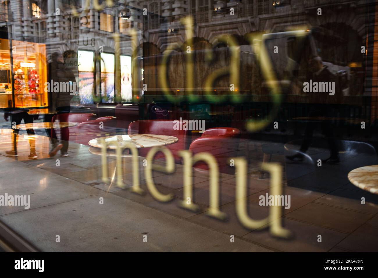 Il 18 novembre 2020 la gente passa davanti ai tavoli vuoti di un caffè temporaneamente chiuso su Regent Street a Londra, Inghilterra. In tutta l'Inghilterra negozi non essenziali, bar, ristoranti e altre aziende del settore alberghiero rimangono chiusi come parte del secondo blocco nazionale del coronavirus, iniziato il 5 novembre e in scadenza il 2 dicembre. Il primo ministro britannico Boris Johnson, che ha dichiarato di non voler estendere il blocco, nel frattempo rimane in isolamento a Downing Street dopo essere venuto in contatto con un deputato giovedì scorso che ha poi provato positivo per il covid Foto Stock