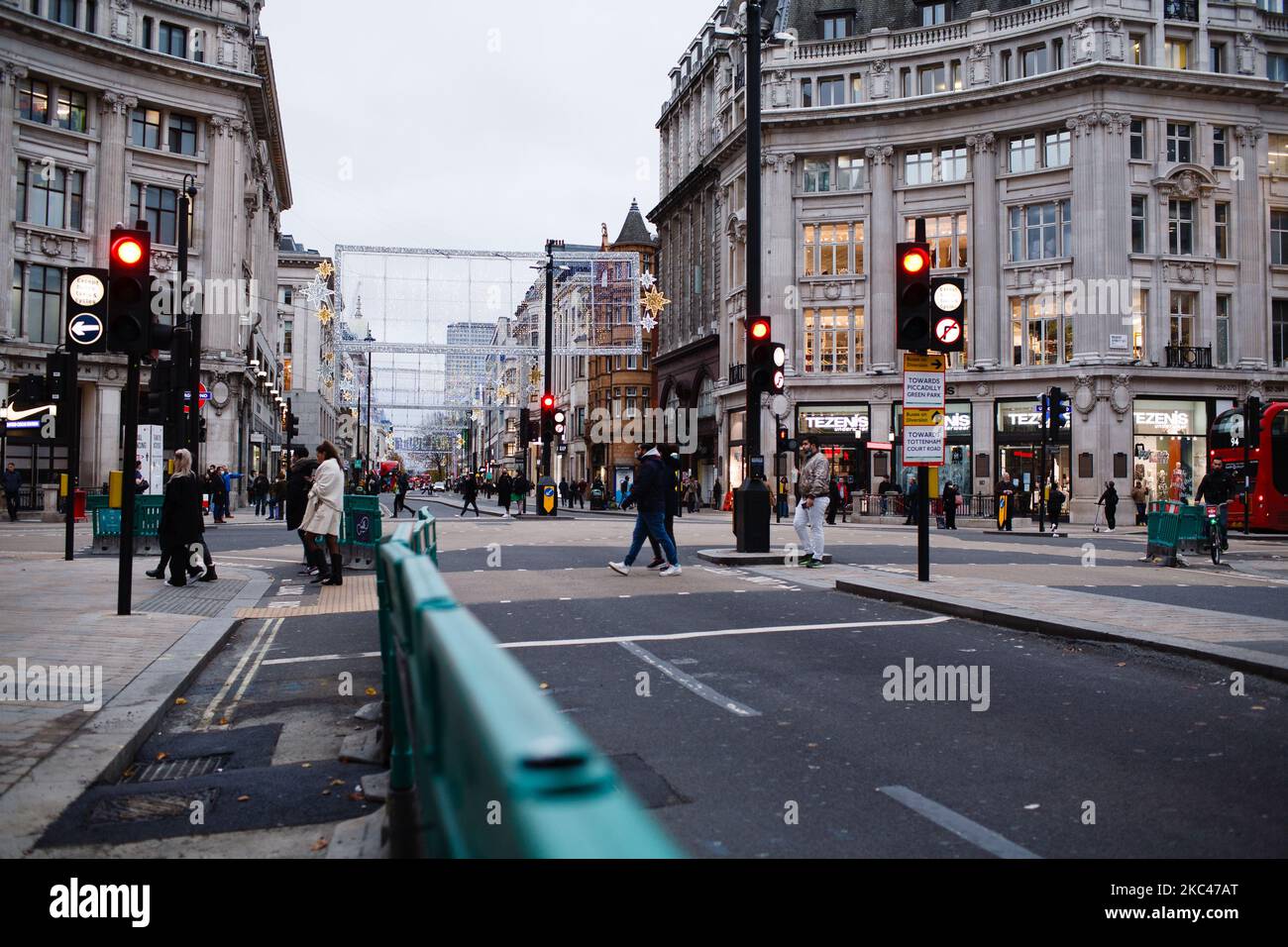 La gente attraversa Oxford Circus a Londra, Inghilterra, il 18 novembre 2020. In tutta l'Inghilterra negozi non essenziali, bar, ristoranti e altre aziende del settore alberghiero rimangono chiusi come parte del secondo blocco nazionale del coronavirus, iniziato il 5 novembre e in scadenza il 2 dicembre. Il primo ministro britannico Boris Johnson, che ha indicato di non voler estendere il blocco, nel frattempo rimane in isolamento a Downing Street dopo essere venuto in contatto con un deputato giovedì scorso che ha poi testato positivo per il covid-19. Il primo ministro stesso, che è stato ricoverato in ospedale Foto Stock