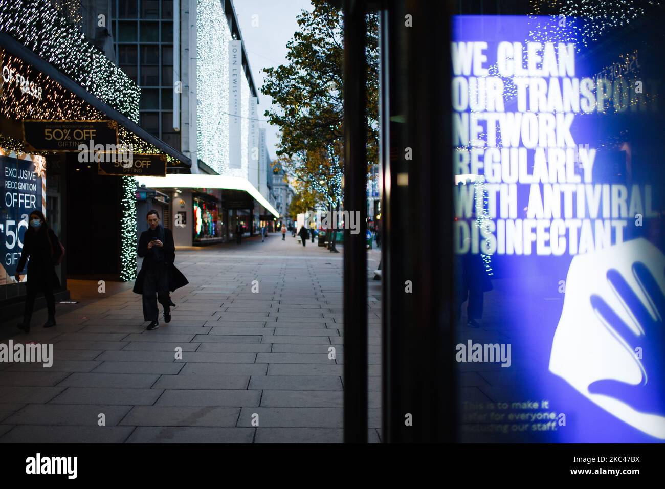 Un segnale che rassicura gli utenti dei trasporti pubblici di pulizia disinfettante regolare illumina lo schermo di pubblicità digitale di una fermata di autobus su una tranquilla Oxford Street a Londra, Inghilterra, il 18 novembre 2020. In tutta l'Inghilterra negozi non essenziali, bar, ristoranti e altre aziende del settore alberghiero rimangono chiusi come parte del secondo blocco nazionale del coronavirus, iniziato il 5 novembre e in scadenza il 2 dicembre. Il primo ministro britannico Boris Johnson, che ha indicato di non voler estendere il blocco, nel frattempo rimane in isolamento a Downing Street dopo la sua presenza Foto Stock