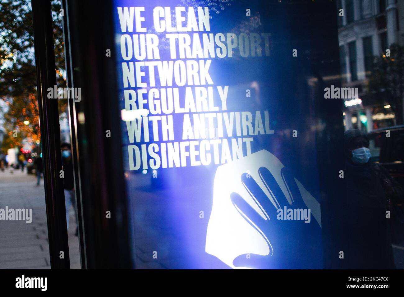 Un segnale che rassicura gli utenti dei trasporti pubblici di pulizia disinfettante regolare illumina lo schermo di pubblicità digitale di una fermata di autobus su una tranquilla Oxford Street a Londra, Inghilterra, il 18 novembre 2020. In tutta l'Inghilterra negozi non essenziali, bar, ristoranti e altre aziende del settore alberghiero rimangono chiusi come parte del secondo blocco nazionale del coronavirus, iniziato il 5 novembre e in scadenza il 2 dicembre. Il primo ministro britannico Boris Johnson, che ha indicato di non voler estendere il blocco, nel frattempo rimane in isolamento a Downing Street dopo la sua presenza Foto Stock