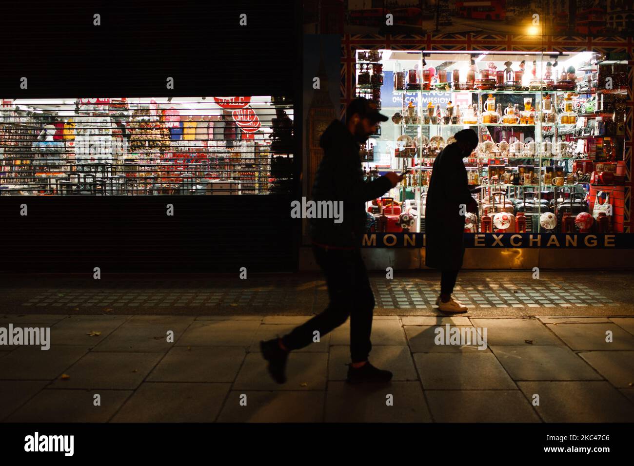 Il 18 novembre 2020, la gente passa davanti ai cimeli a tema londinese esposti nella finestra di un negozio di souvenir turistico temporaneamente chiuso a Oxford Street a Londra, Inghilterra. In tutta l'Inghilterra negozi non essenziali, bar, ristoranti e altre aziende del settore alberghiero rimangono chiusi come parte del secondo blocco nazionale del coronavirus, iniziato il 5 novembre e in scadenza il 2 dicembre. Il primo ministro britannico Boris Johnson, che ha indicato di non voler estendere il blocco, nel frattempo rimane in isolamento a Downing Street dopo essere venuto in contatto con una M. Foto Stock