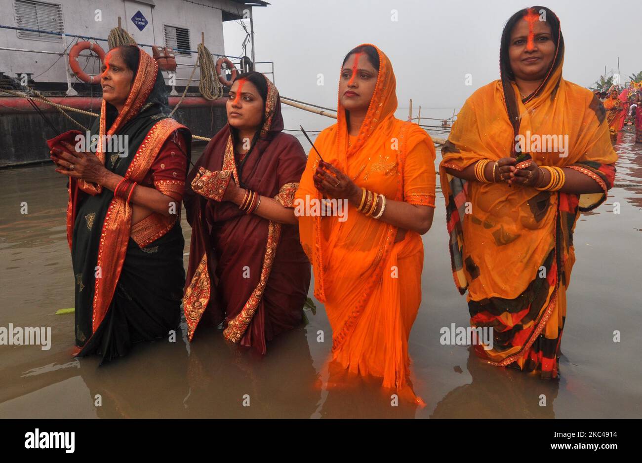 I devoti indù offrono preghiere durante il Chhath Puja Festival sulle rive del fiume Brahmaputra a Guwahati su NovemberÂ 20,2020.Â il Chhath Festival, noto anche come Surya Pooja, o culto del sole, è osservato inÂ IndiaÂ e vede i devoti rendere omaggio al Dio sole e acqua. (Foto di Anuwar Hazarika/NurPhoto) Foto Stock