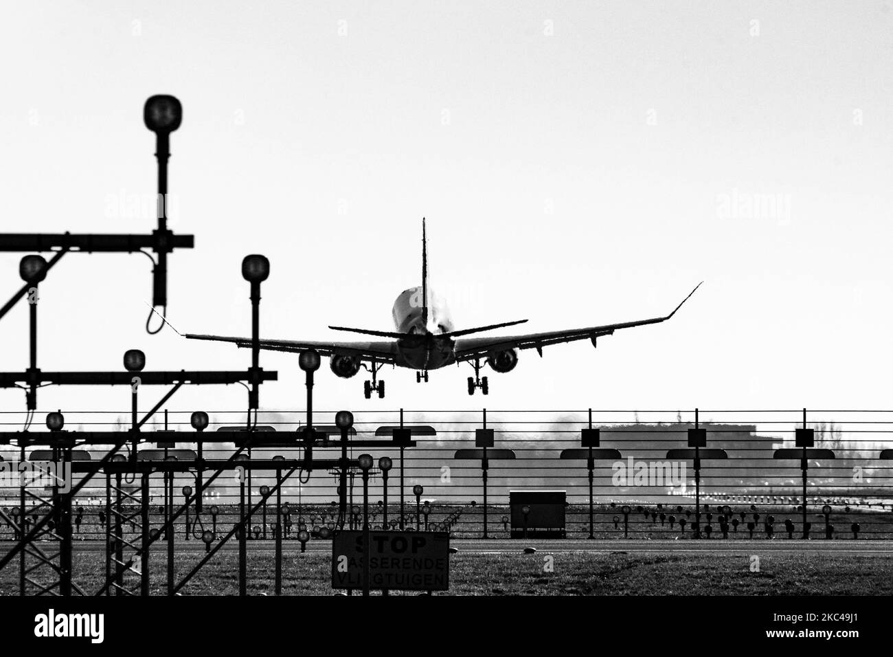 Foto in bianco e nero della vista posteriore di vari aerei che atterrano dietro le luci della pista di Amsterdam Schiphol AMS EHAM International Airport nei Paesi Bassi. Il traffico mondiale di passeggeri è diminuito durante l'era pandemica del coronavirus covid-19, con l'industria che lotta per sopravvivere. Amsterdam, Paesi Bassi il 18 novembre 2020 (Foto di Nicolas Economou/NurPhoto) Foto Stock