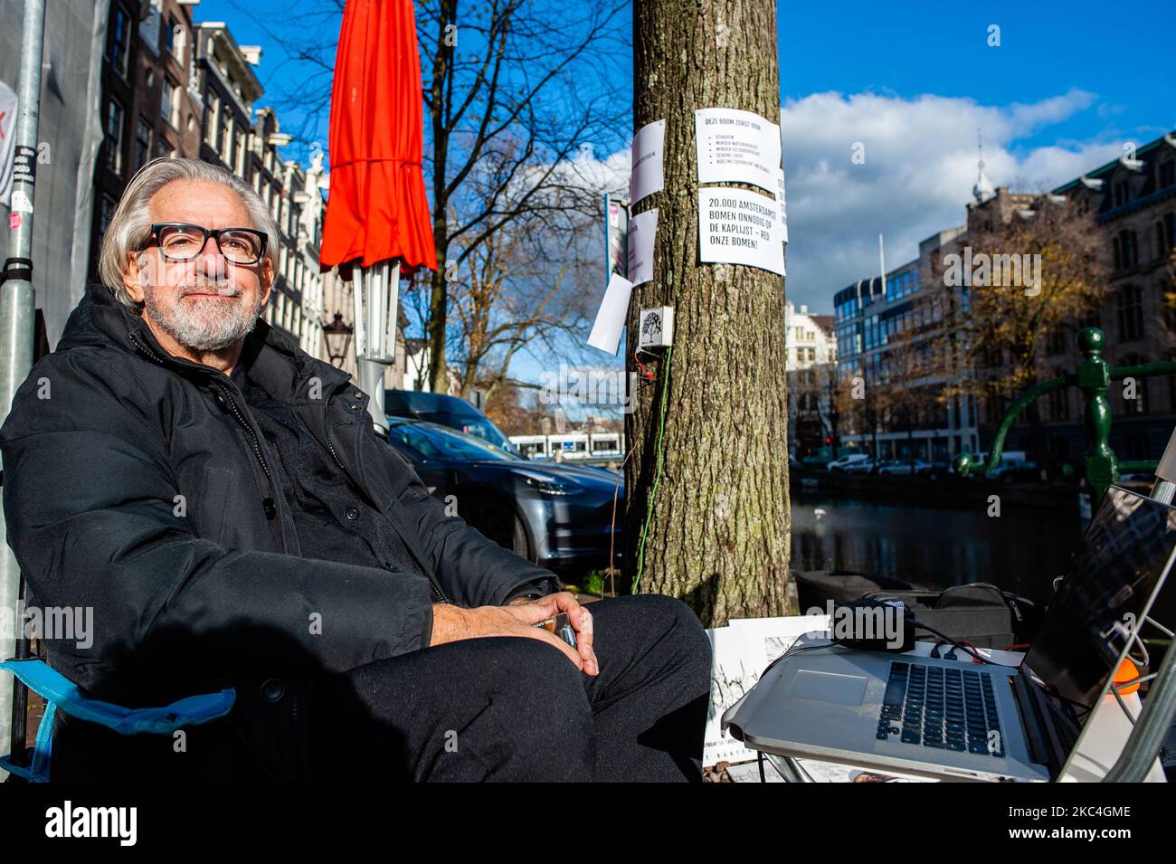 L'artista e musicista olandese, Bert Barten, sta producendo musica collegando un sistema audio all'albero e da lì al suo computer, durante la protesta musicale contro il taglio di alberi nel centro di Amsterdam, il 23rd novembre 2020. (Foto di Romy Arroyo Fernandez/NurPhoto) Foto Stock