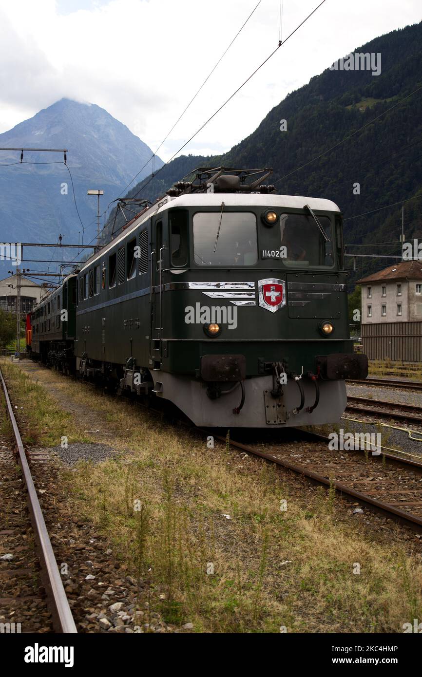 Una vista verticale di uno storico treno FFS AE 6 e 6 con montagne sullo sfondo a Erstfeld, Svizzera Foto Stock