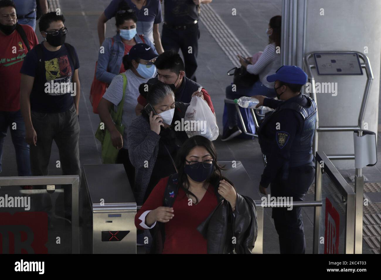 Un agente di polizia femminile distribuisce gel antibatterico ai passeggeri di una stazione del metrobus a Città del Messico. Le autorità di Città del Messico hanno annunciato che il semaforo epidemiologico rimane arancione al limite del rosso perché il numero di persone ricoverate in ospedale per COVID-19 è aumentato nella capitale. Hanno riferito che per ridurre il numero di infezioni e ricoveri ospedalieri, le ore degli stabilimenti commerciali continueranno fino alle 7:00 per evitare la folla. (Foto di Gerardo Vieyra/NurPhoto) Foto Stock