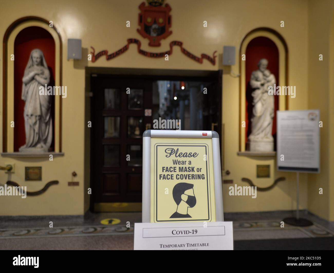 Un cartello con la scritta "Please wear face Mask or Face Cover" visto all'ingresso della Whitefriar Street Church, nel centro di Dublino. Taoiseach (PM irlandese) Micheal Martin ha annunciato venerdì scorso piani per l'allentamento delle restrizioni di blocco a livello nazionale di livello 5 e la riapertura del paese per un certo numero di fasi da domani nel periodo precedente a Natale. La prima fase vedrà tutti i negozi, parrucchieri, palestre, cinema, musei, possibilità di riaprire gallerie e biblioteche. I luoghi di culto riapriranno per i servizi con misure restrittive, mentre riunioni di 15 persone possono avere luogo all'aperto. Lunedì, Foto Stock