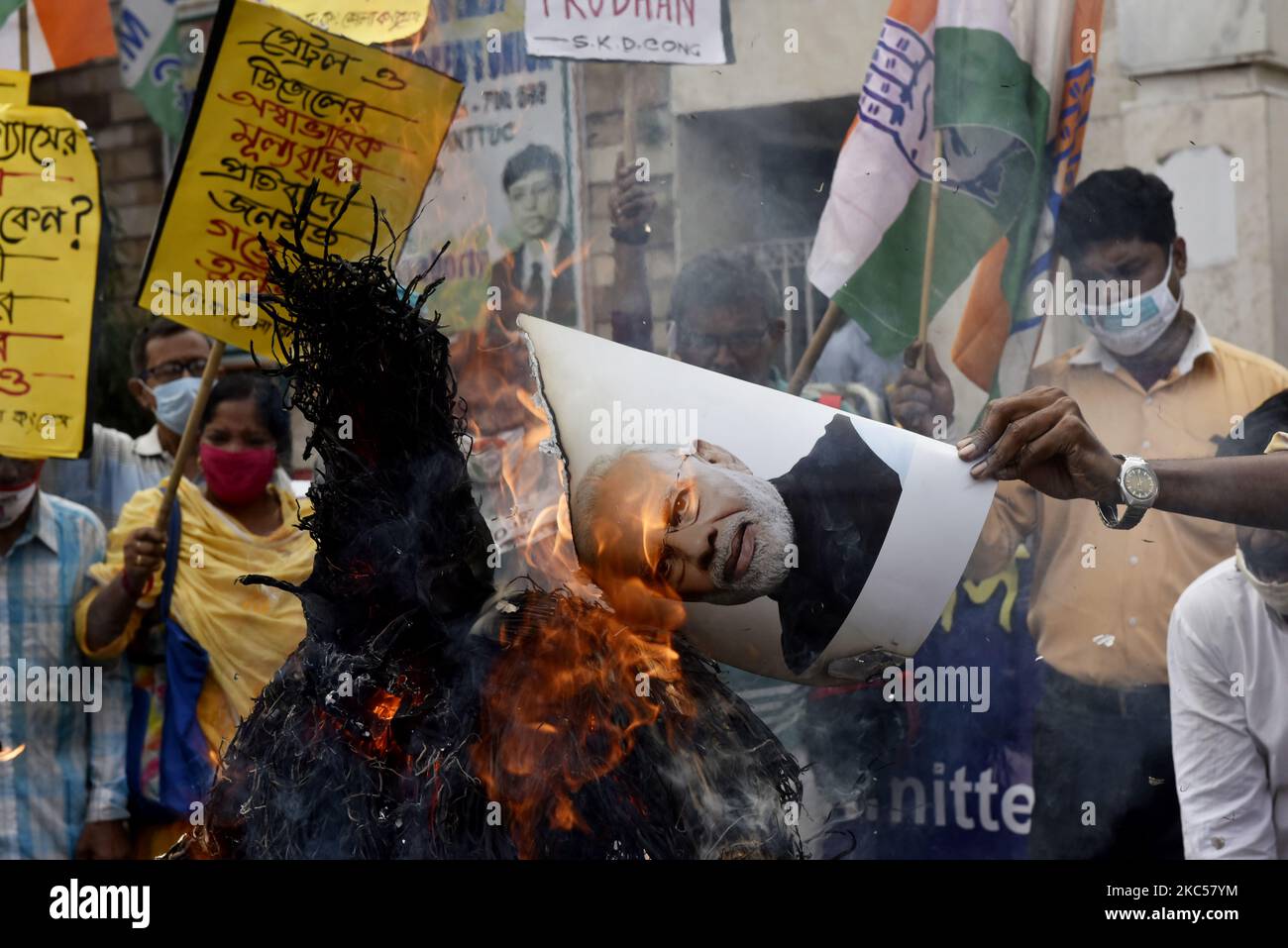 I lavoratori del partito del Congresso indiano bruciano una foto del primo ministro indiano Narendra modi e un'effigie del ministro indiano per il petrolio, il gas naturale e l'acciaio Dharmendra Pradhan durante una protesta contro il recente aumento dei prezzi dei prodotti petroliferi e di altri beni essenziali, Kolkata, India, 04 dicembre 2020. (Foto di Indranil Aditya/NurPhoto) Foto Stock