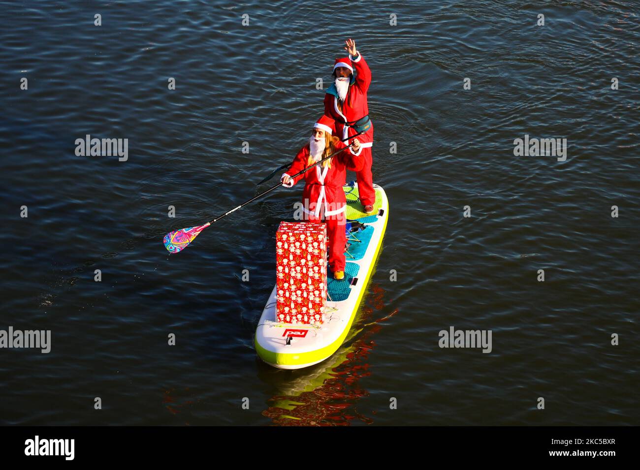 I surfisti che indossano i costumi di Babbo Natale galleggiano sul fiume Vistola durante un evento di beneficenza il giorno di San Nicola a Cracovia, in Polonia. Dicembre 6th, 2020. (Foto di Beata Zawrzel/NurPhoto) Foto Stock