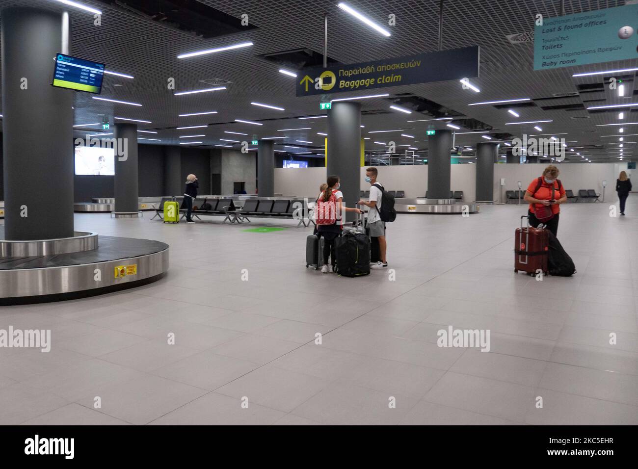 L'interno del nuovo terminal di Salonicco Makedonia International Airport SKG LGTS. L'area della cintura bagagli, di recente costruzione e aperta, è la sala degli arrivi del secondo terminal costruito da Fraport Greece, l'operatore dell'aeroporto dopo la privatizzazione. All'area di ritiro bagagli i passeggeri in arrivo dai voli nazionali sono visti con maschera facciale a causa delle misure di sicurezza pandemiche di Coronavirus. Il traffico mondiale di passeggeri è diminuito durante l'era pandemica del coronavirus covid-19, con l'industria che lotta per sopravvivere. In questo momento il governo permette con un NOTAM solo essenziale viaggiare come Foto Stock