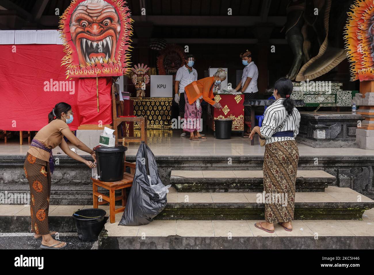 Balinese si lavano le mani prima di votare durante le elezioni regionali in mezzo alla pandemia COVID-19 presso il seggio elettorale nel villaggio di Anggungan a Badung, Bali, Indonesia il 9 dicembre 2020. (Foto di Johanes Christo/NurPhoto) Foto Stock