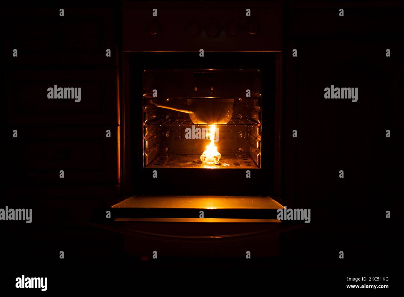 Cucinare in pentole su candele in forni con interruzioni di corrente in Ucraina durante la guerra, blackout di massa Foto Stock