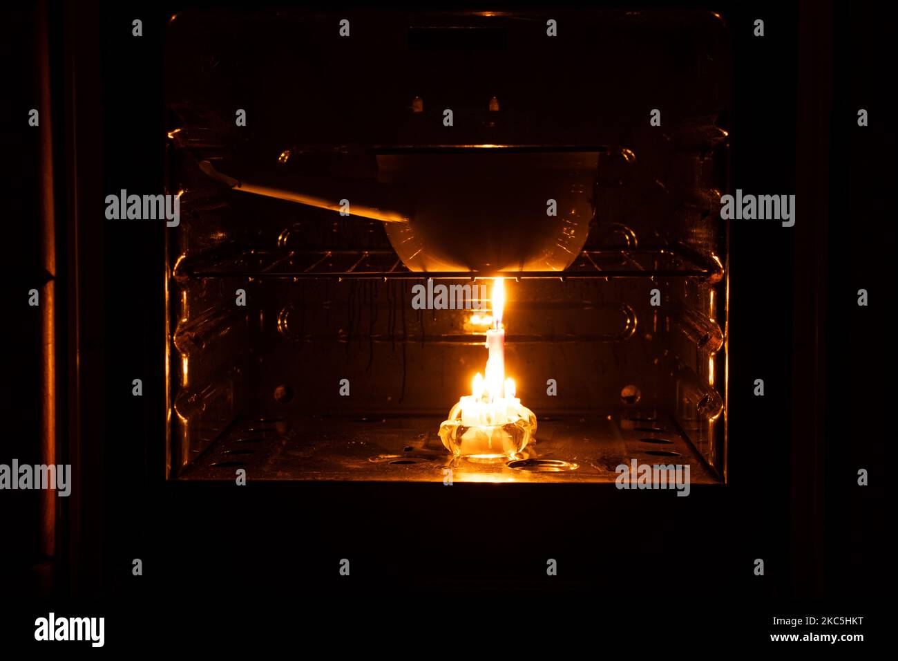 Cucinare in pentole su candele in forni con interruzioni di corrente in Ucraina durante la guerra, blackout di massa Foto Stock