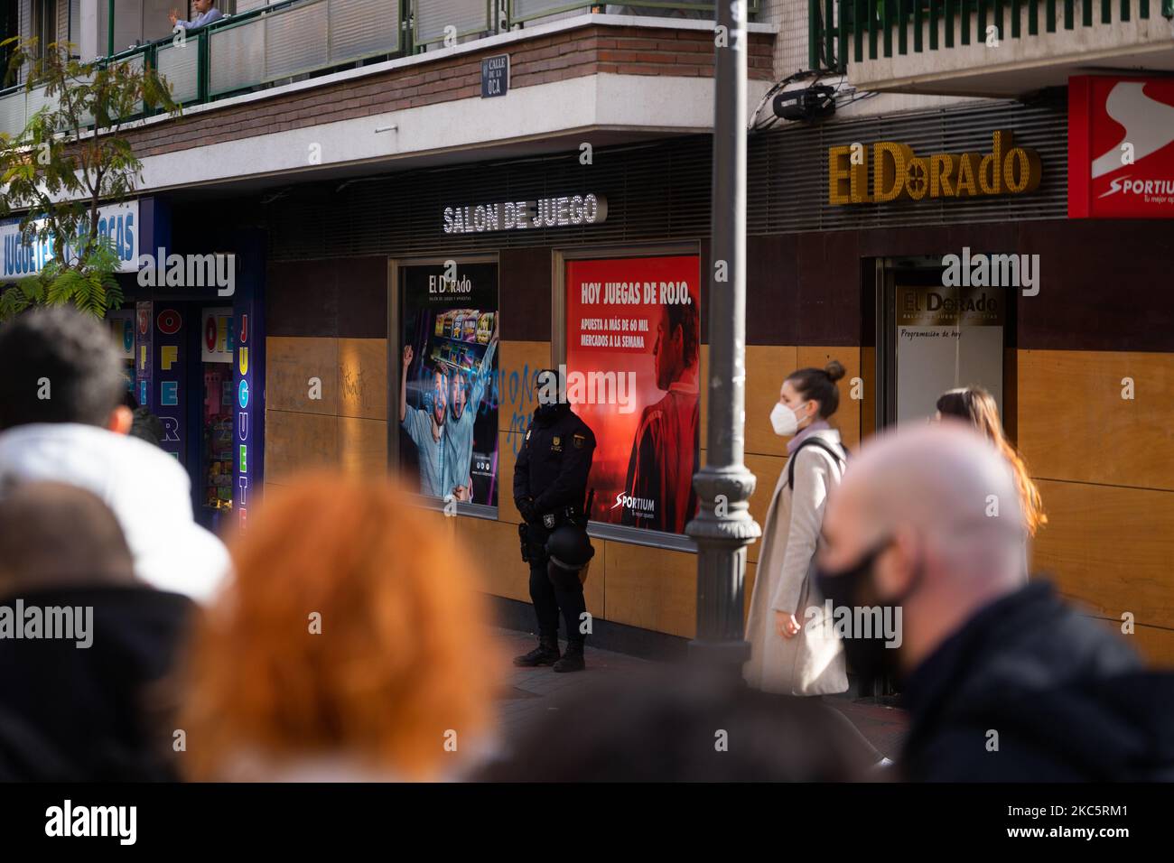 Manifestazione nel quartiere di Carabanchel contro le case di scommesse, a Madrid, Spagna, il 13 dicembre 2020. Un poliziotto alle porte di una sala giochi. (Foto di Jon Imanol Reino/NurPhoto) Foto Stock