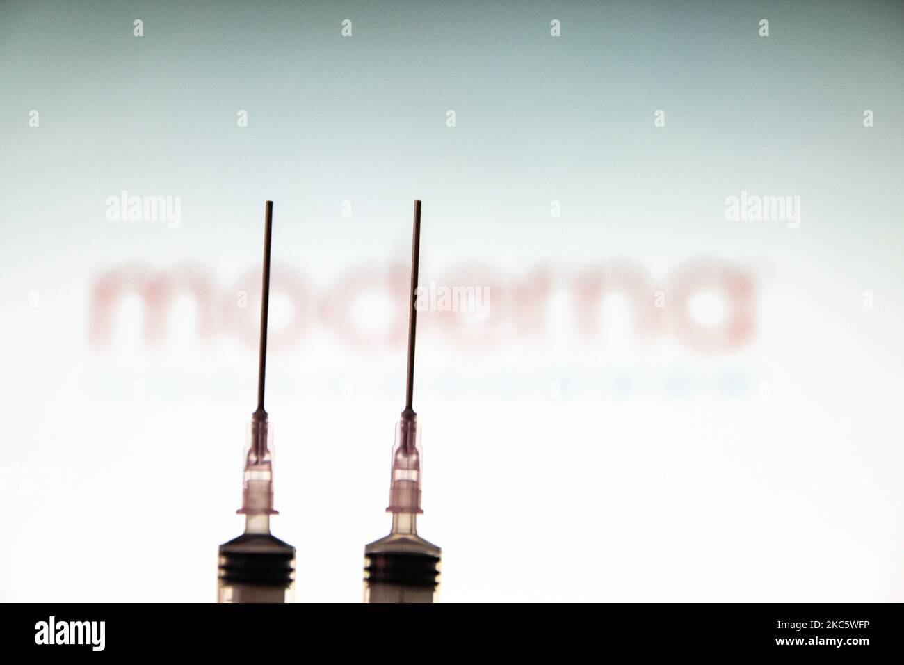 Immagine di una siringa medica con un ago visto davanti al logo della società farmaceutica moderna. Moderna si aspetta la decisione americana, un'approvazione per l'uso di emergenza, il vaccino candidato mRNA-1273 il 17 2020 dicembre dalla FDA e l'approvazione europea per il vaccino COVID-19 nel gennaio del 2021. Moderna è una società di biotecnologia americana con sede a Cambridge, Massachusetts, che sviluppa tecnologie vaccinali basate sull'mRNA messaggero. La pandemia di Coronavirus, una delle più grandi crisi sanitarie del mondo, porterà al più grande programma di vaccinazione nella storia umana. Amste Foto Stock