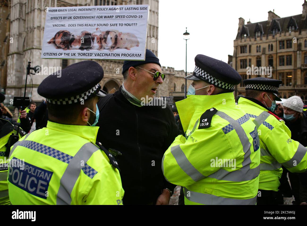 Un attivista che protesta contro le restrizioni di blocco del coronavirus e qualsiasi vaccinazione covid-19 obbligatoria è detenuta da agenti di polizia a Victoria Street a Londra, in Inghilterra, il 14 dicembre 2020. Si prevede che Londra venga imminentemente collocata sotto le restrizioni 'Tier 3', indicando un livello di allerta 'molto alto' per il coronavirus, e richiedendo che pub, bar, caffè e ristoranti si chiudano oltre ad offrire servizio di asporto e consegna. La città è stata restituita al livello 2, o 'alto' allarme, restrizioni alla fine del blocco di quattro settimane in tutta l'Inghilterra il 2 dicembre, anche se con alcune disposizioni di rafforzamento havi Foto Stock