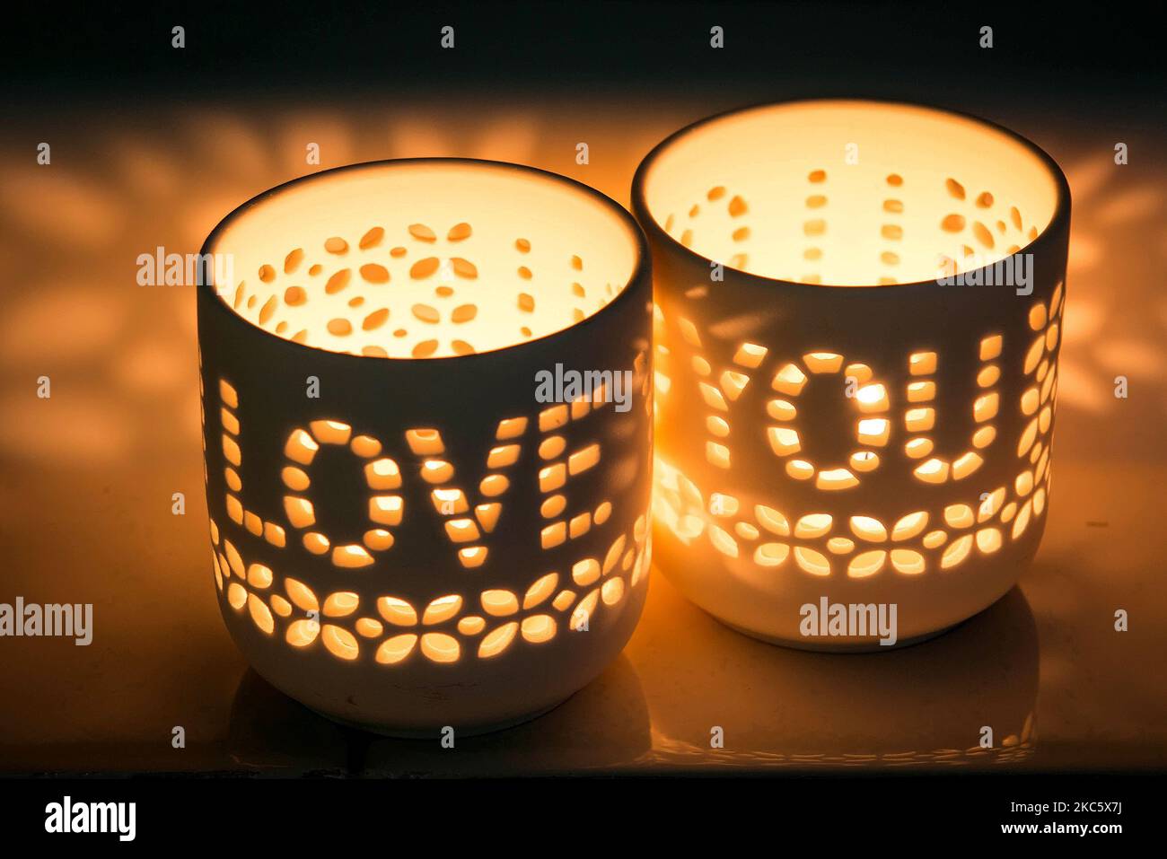 Un primo piano di un paio di candele romantiche con le parole 'Love you' scolpite in loro, luminoso Foto Stock